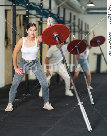 Athletic young woman doing barbell exercises in crossfit gym Athletic young woman doing barbell exercises in crossfit gym 132044366