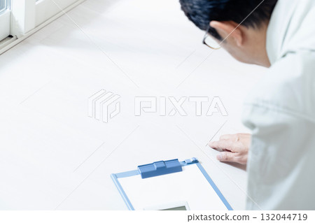 A man in work clothes checking the floor 132044719