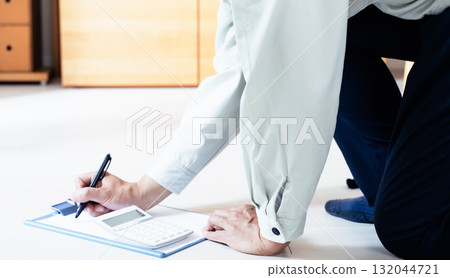 一名身穿工作服的男子正在檢查地板 132044721