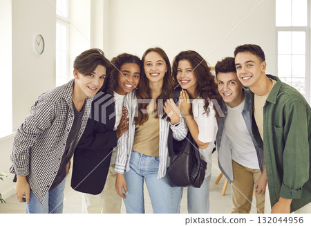 Smiling happy high school students standing together and looking cheerful at camera. 132044956