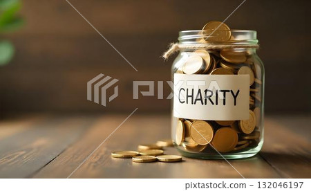 A wooden table displays a charity jar filled with coins, emphasizing humanitarian aid and the act of giving back A wooden table displays a charity jar filled with coins, emphasizing humanitarian aid and the act of giving back 132046197
