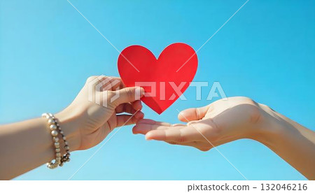 Two hands hold a red heart-shaped paper, symbolizing charity and community support on International Day of Charity 132046216