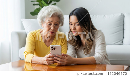 一名年輕女子正在教導一位老人如何使用智慧型手機 132046570