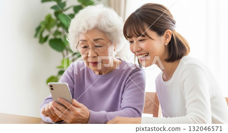 一名年輕女子正在教導一位老人如何使用智慧型手機 132046571