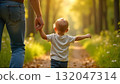 A man and child stroll down a forest path, embodying happiness and family spirit on International Children's Day 132047314
