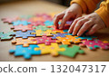 A small hand touches a puzzle piece, representing joy and playfulness in celebration of International Children's Day 132047317