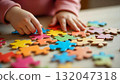 A child's hand interacts with a vibrant puzzle piece, embodying fun and creativity during International Children's Day festivities 132047318