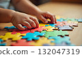 A young child's hand reaches for a puzzle piece, celebrating imagination and unity on International Children's Day 132047319