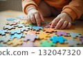 A child's hand touches a colorful puzzle piece, symbolizing creativity and joy on International Children's Day 132047320