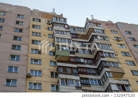 Worn apartment building with balconies in urban setting Worn apartment building with balconies in urban setting 132047520