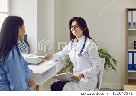 Female doctor with glasses smiles and explains results of positive dynamics of treatment after examination. 132047571