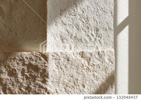 Light and shadow play on textured stone wall 132048437
