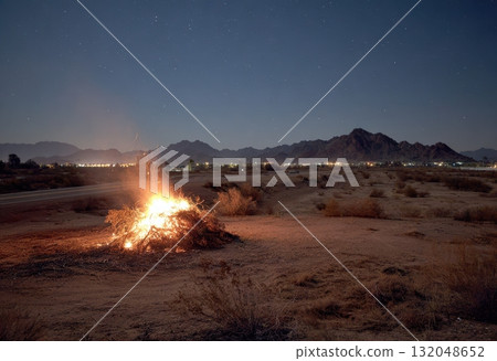 Night bonfire brightens desert landscape under stars 132048652