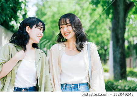 Female friends walking while chatting Female friends walking while chatting 132049242