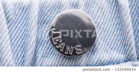 Old metal button closeup on blue jeans Old metal button closeup on blue jeans 132049834