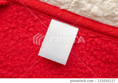 Blank white laundry care clothes label on red shirt fabric texture background 132050117
