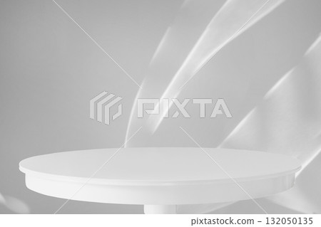 Round white wood table top with abstract shadow drop on white wall background for mockup product display Round white wood table top with abstract shadow drop on white wall background for mockup product display 132050135