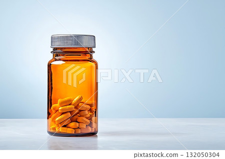 Amber Bottle Filled with Yellow Pills on a Light Background for Health and Wellness Concepts 132050304