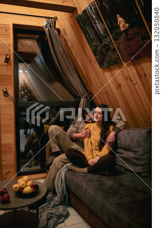 Cozy evening in a wooden cabin with a couple enjoying each other's company 132050840