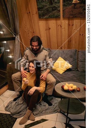 Couple enjoying cozy moments at home during a winter evening with snacks and warmth Couple enjoying cozy moments at home during a winter evening with snacks and warmth 132050841