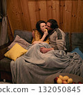 Cozy indoor evening with couple sharing a playful moment on the couch 132050845