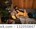 Cozy indoor moment between a couple enjoying each other's company in a wooden cabin 132050847