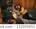 Cozy evening on the couch with a couple enjoying each other's company in a wooden cabin 132050852