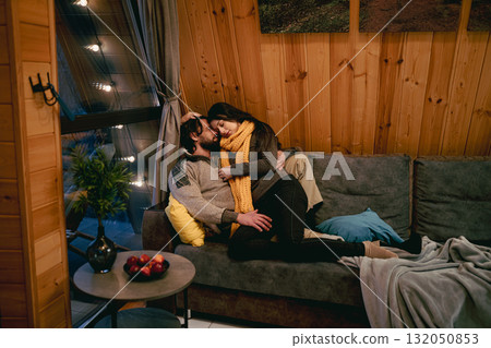 Cozy indoor moment between a couple in cabin setting during winter Cozy indoor moment between a couple in cabin setting during winter 132050853