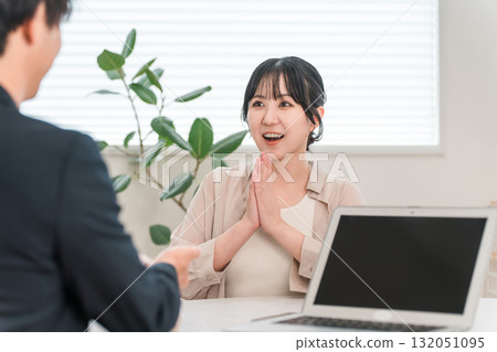 一位女顧客在商務會議上聽銷售員講話時感到驚訝和微笑 132051095