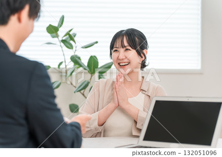 一位女顧客在商務會議上聽銷售員講話時微笑 132051096