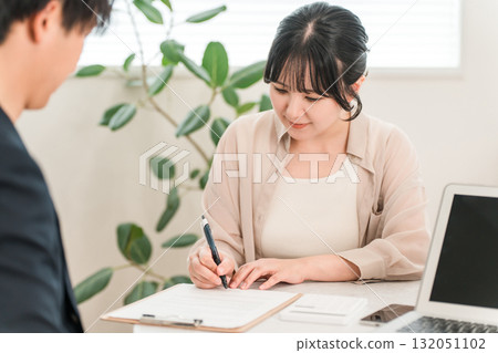 一位男商人向一位女顧客解釋簽約、承諾或同意書 132051102