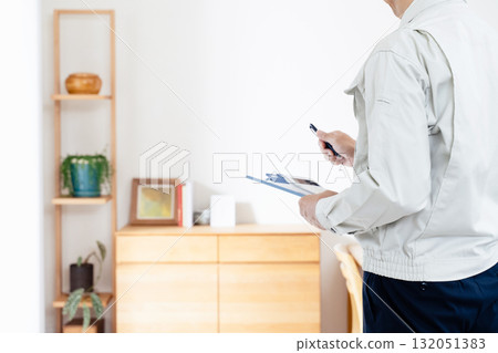 一名身穿工作服的男子正在檢查家具 132051383