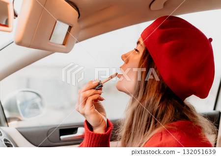 Woman makeup car, applying lip gloss using vanity mirror on the go. 132051639
