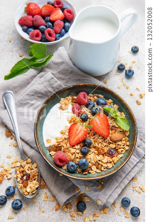 Granola bowls with berries, yogurt, nuts, and honey for breakfast 132052008