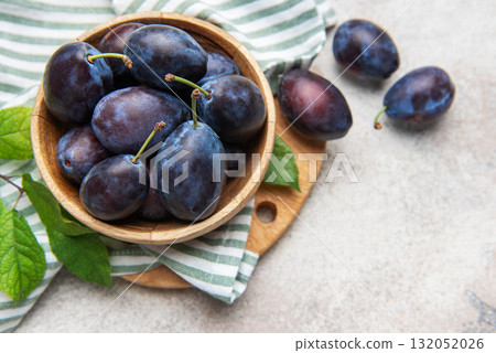 Fresh ripe plums filling a wooden bowl Fresh ripe plums filling a wooden bowl 132052026