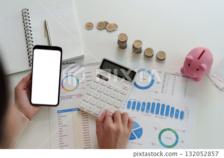Financial Planning. Woman calculating budget with smartphone and calculator. Financial Planning. Woman calculating budget with smartphone and calculator. 132052857