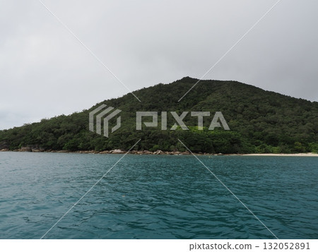 Fitzroy Island – a tranquil cove surrounded by green islands and cloudy skies 132052891