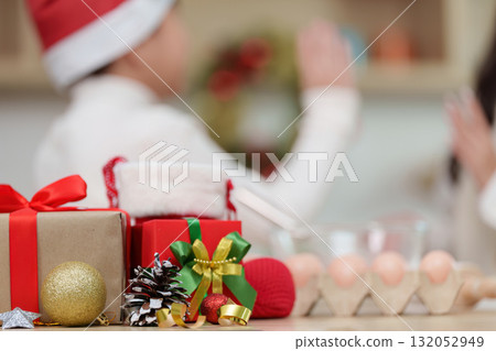 Christmas Celebration. Family bonding while decorating holiday cookies in festive kitchen. 132052949