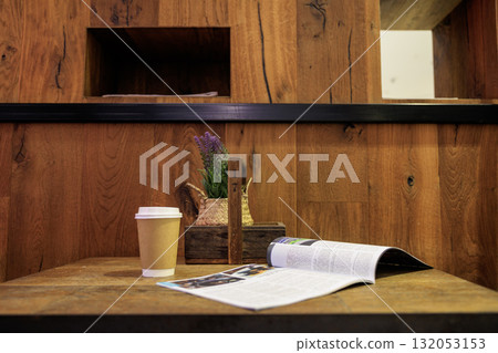 An open magazine and coffee in a corner of an empty cafe An open magazine and coffee in a corner of an empty cafe 132053153