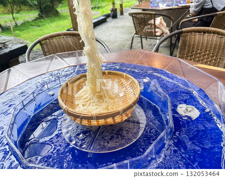 Japanese Nagashi Somen. Somen noodles are picked up with chopsticks. A typical summer scene. 132053464