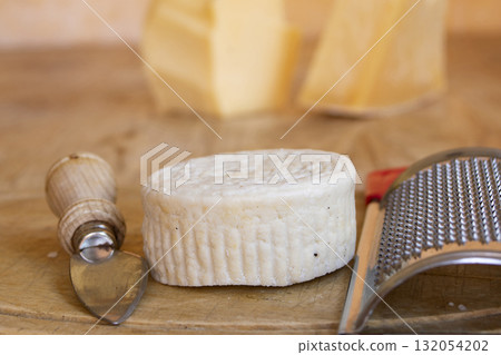 icotta salata cheese with metal grater on wooden cutting board italian hard cheese for grating 132054202