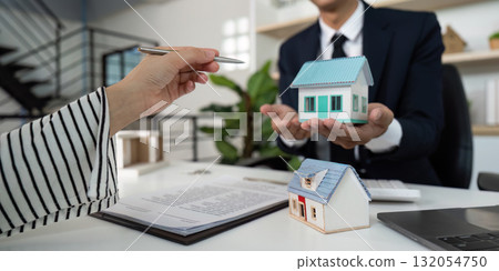 Real Estate Agent Presenting Property Models to Client During Consultation. Real Estate Agent Presenting Property Models to Client During Consultation. 132054750