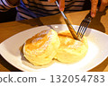 A woman cutting fluffy pancakes 132054783