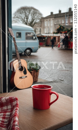 A steaming cup of coffee topped with whipped cream sits on a checkered tablecloth, with a charming serving booth in the background 132055140
