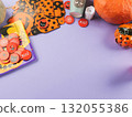 Halloween purple frame background flatlay with pumpkins and party decor 132055386