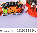 Halloween purple frame background flatlay with pumpkins and party decor 132055391
