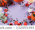 Halloween purple frame background flatlay with pumpkins and party decor 132055393