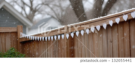 Wooden and fabric hearts are strung together in a snowy landscape, creating a charming winter decoration in a serene outdoor scene Wooden and fabric hearts are strung together in a snowy landscape, creating a charming winter decoration in a serene outdoor scene 132055441