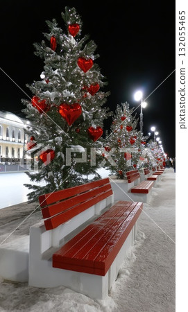 Two frosted trees with silver ornaments are placed along a snowy walkway, contributing to the winter holiday spirit Two frosted trees with silver ornaments are placed along a snowy walkway, contributing to the winter holiday spirit 132055465