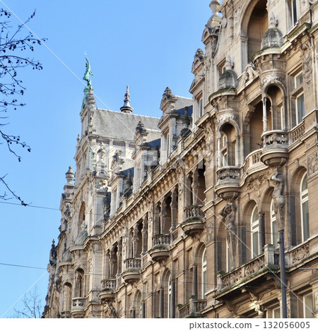 Historic facade detail of an ornate European building featuring classical statues and decorative balconies. Antwerp, Belgium 132056005